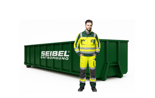 Seibel Mitarbeiter in Arbeitskleidung vor einem grünen Abrollcontainer